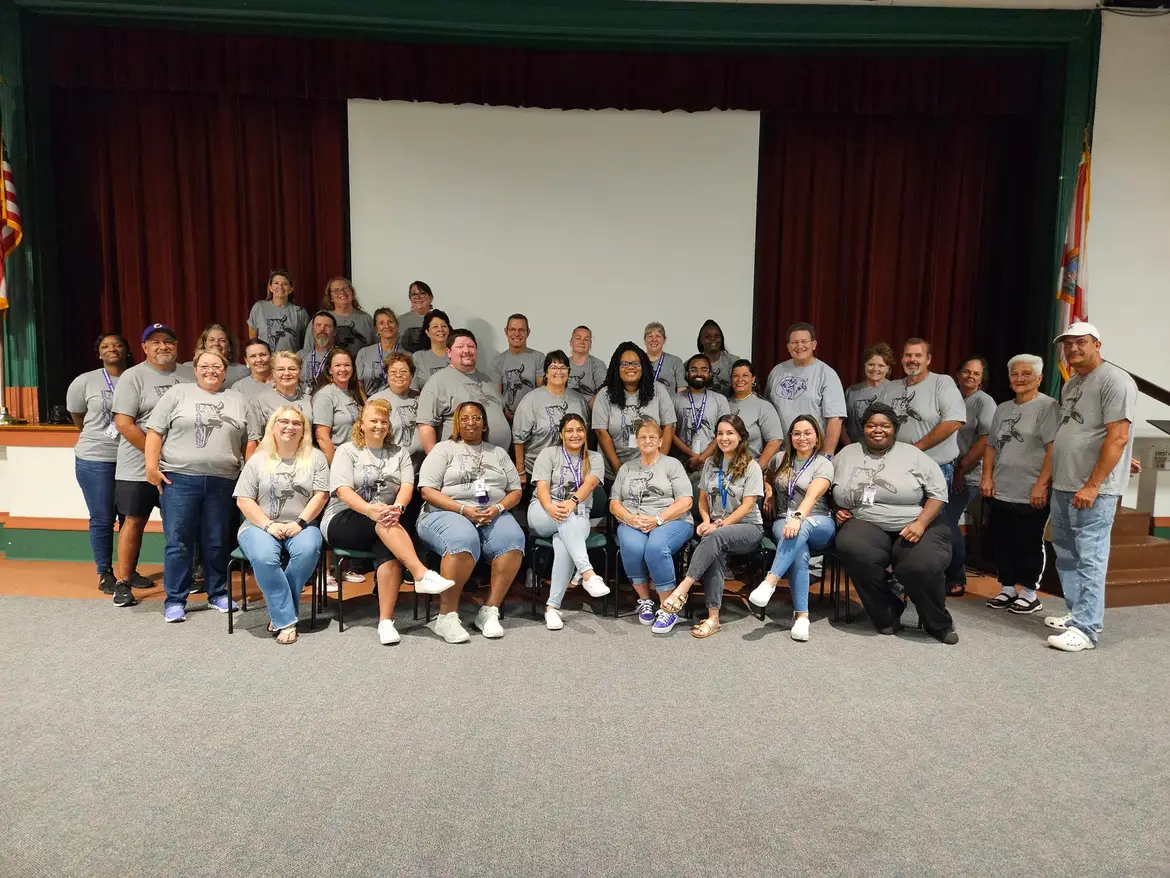 Faculty in Matching Shirts in Auditorium