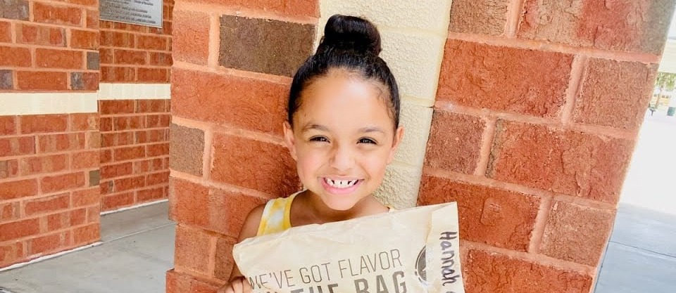 Girl smiling holding a bag