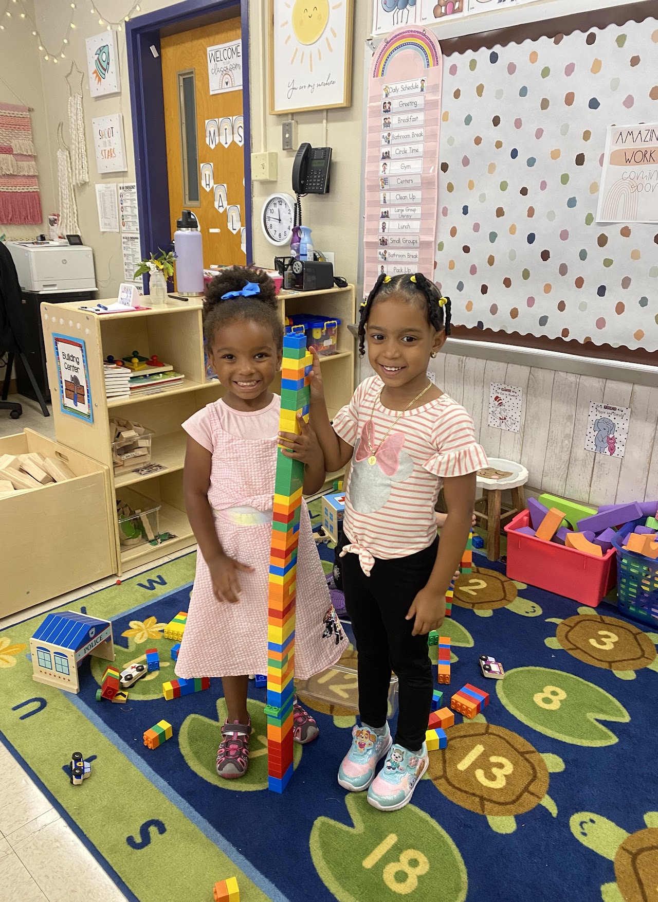 Two children proud of their tall lego structure