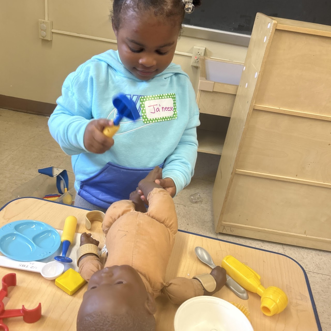 Child playing with a toy doll as a doctor