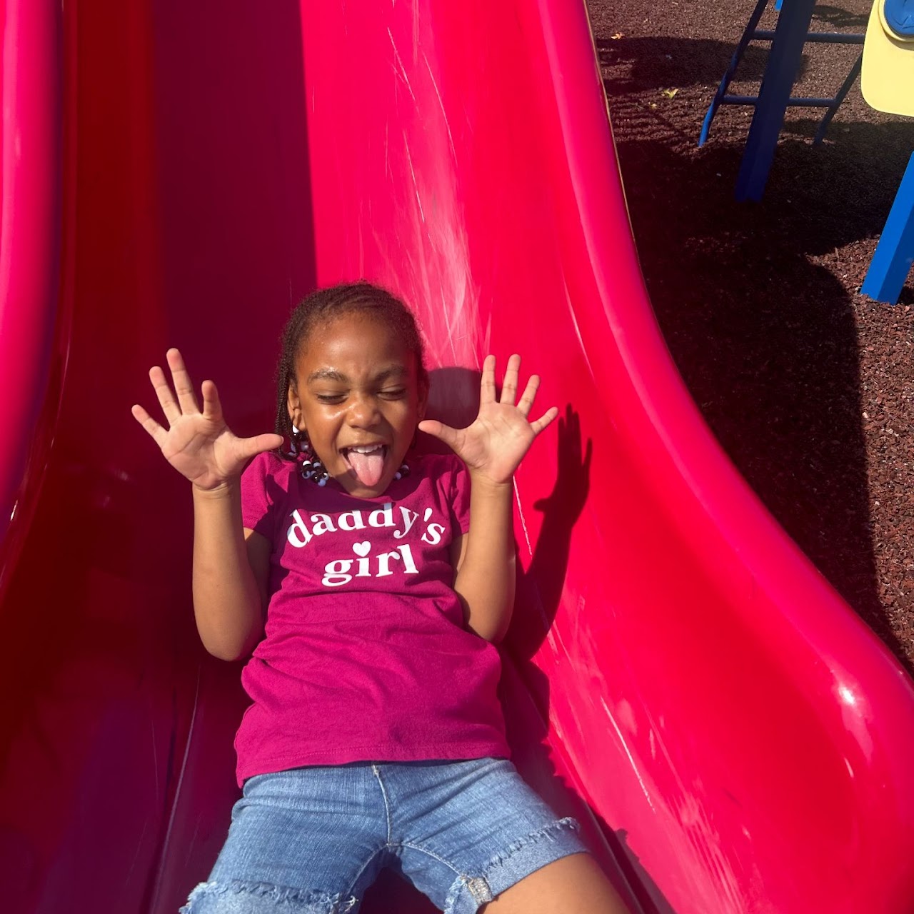 A young girl sliding down a slide