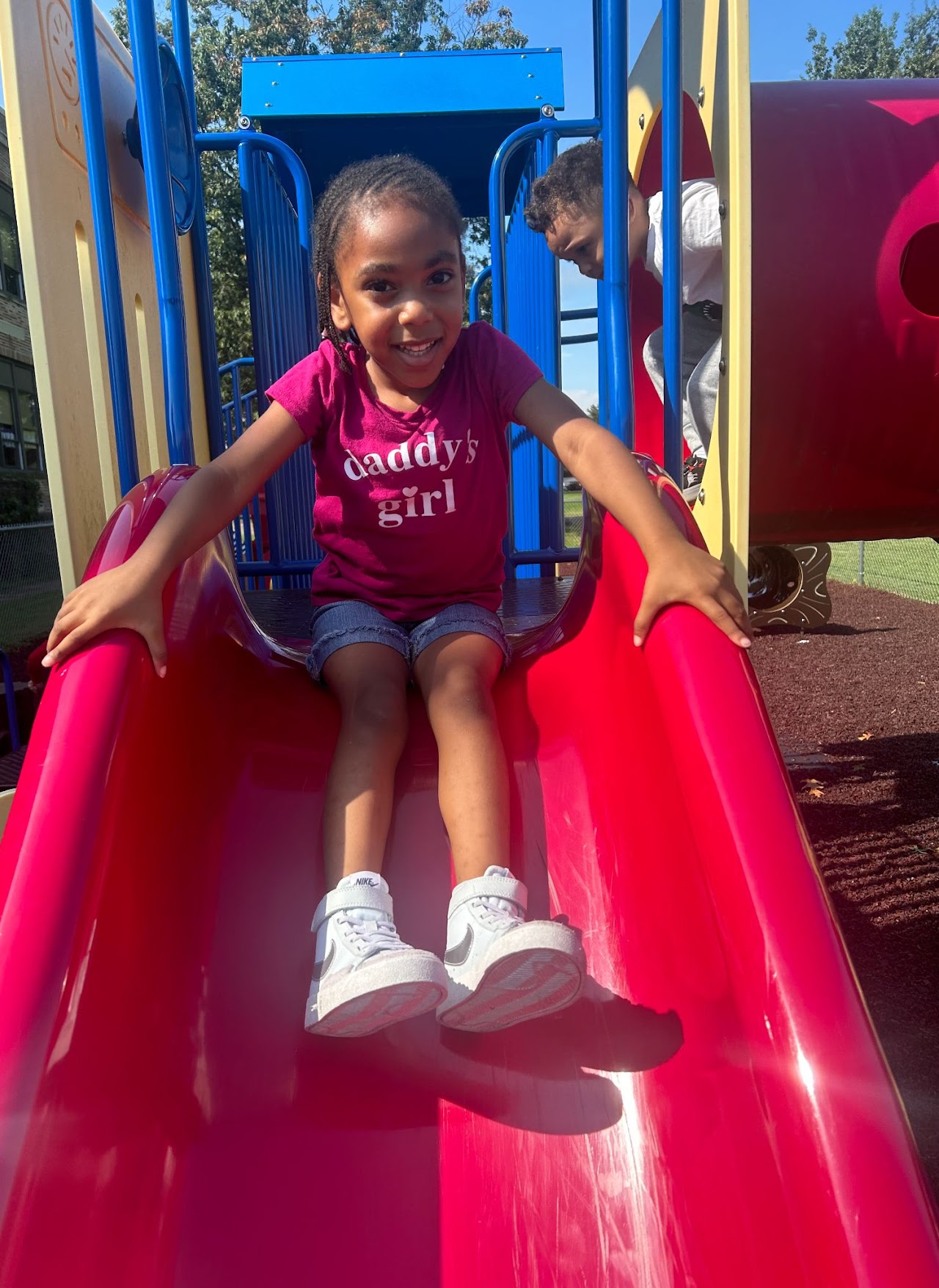 A young girl sliding down a slide 3