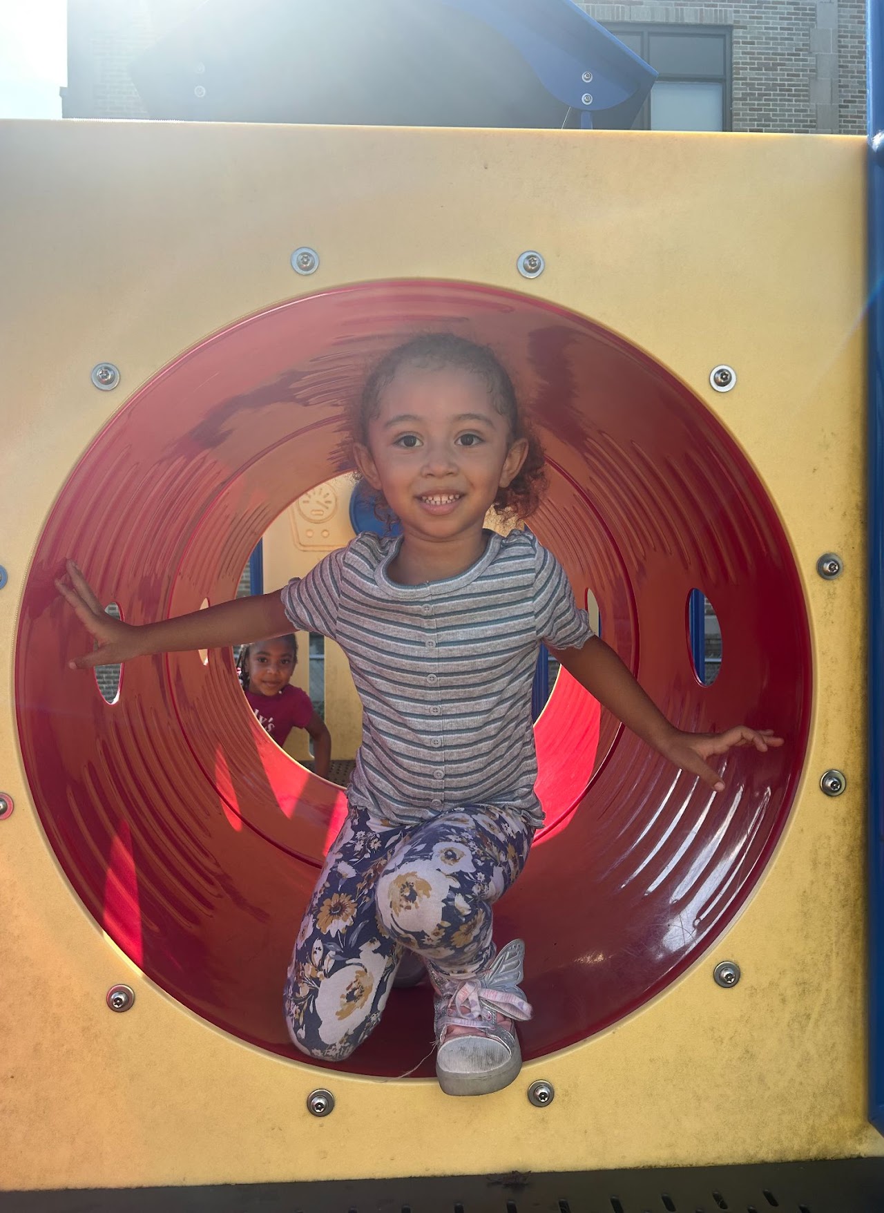 A young girl inside of a tube