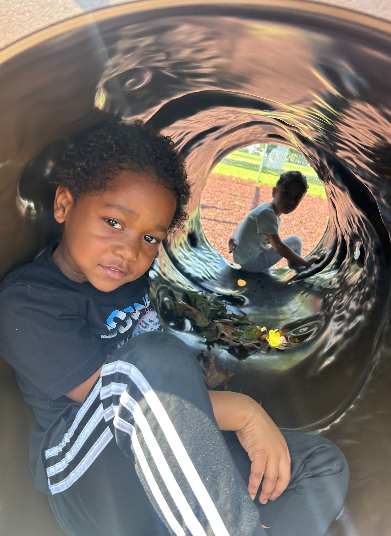 A picture of two children sitting on each end of a tube