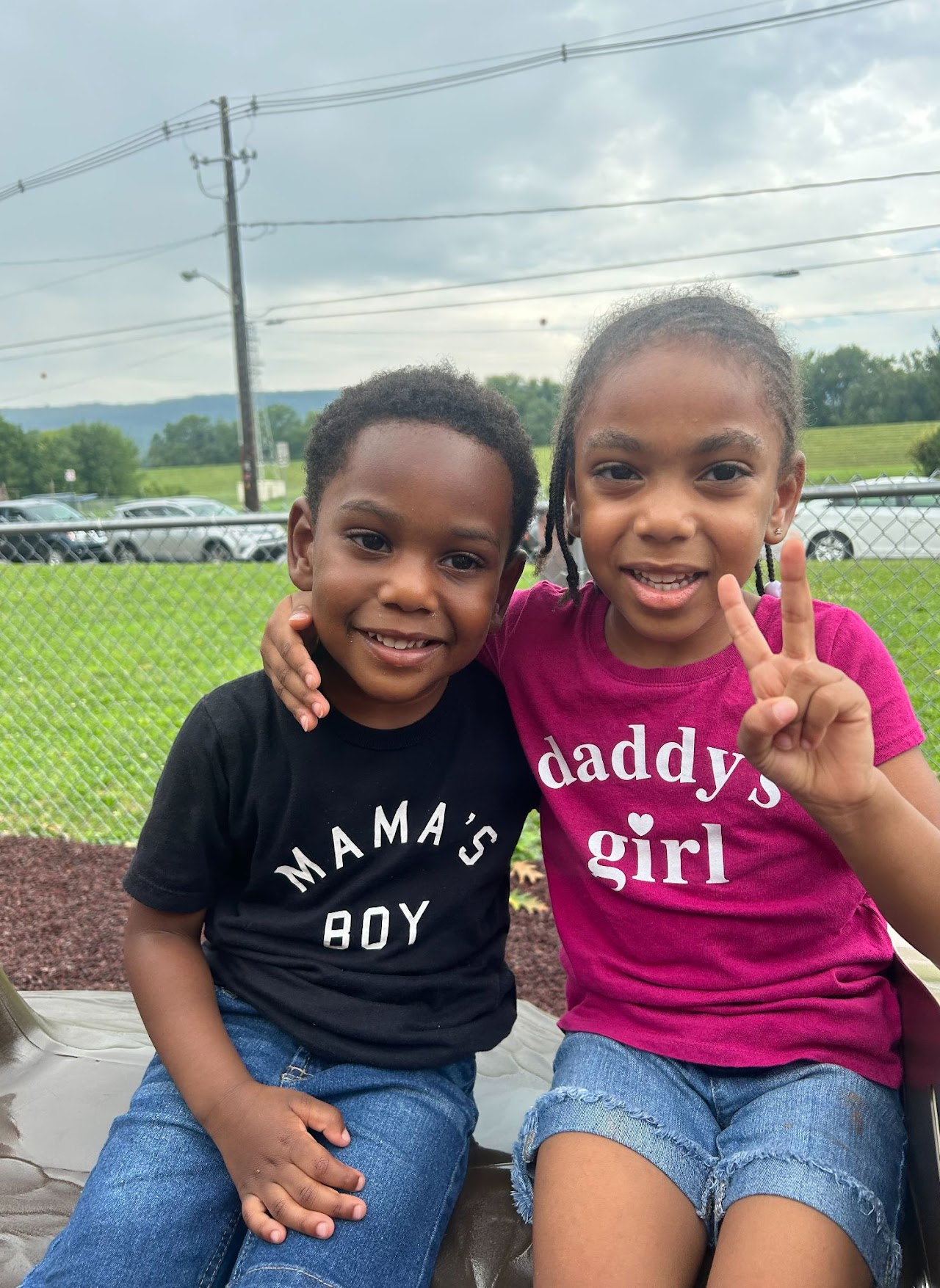 Two children posing, with the girl doing a peace sign