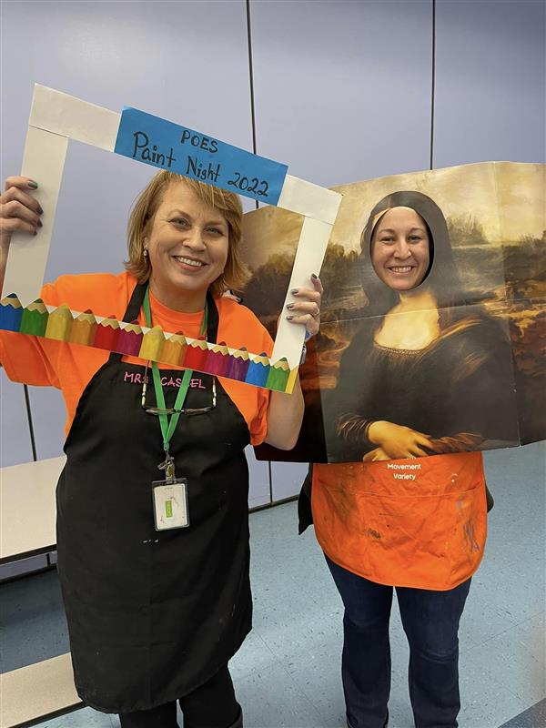 teachers pose with posters with cutouts through which their faces are seen. One poster is a colorful frame that makes it appear her face is a framed work of art, and the other is a replica of The Mona Lisa, with a cutout where the face would be - the teacher's face is visible in the cutout.