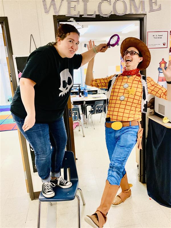 two teachers pose in their Halloween costumes. They are dressed as Sid and Woody from Toy Story