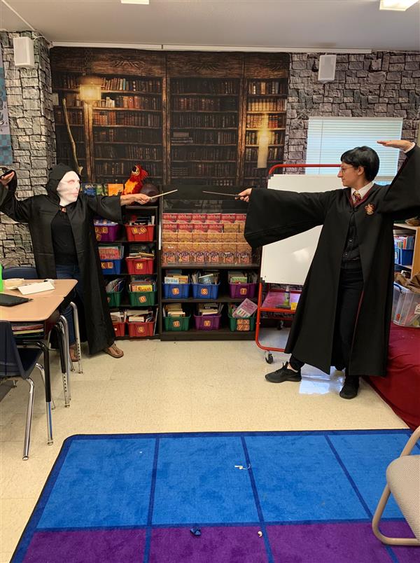 two students are dressed as Voldemort and Harry Potter. They stand opposed to each other with wands drawn, as if dueling