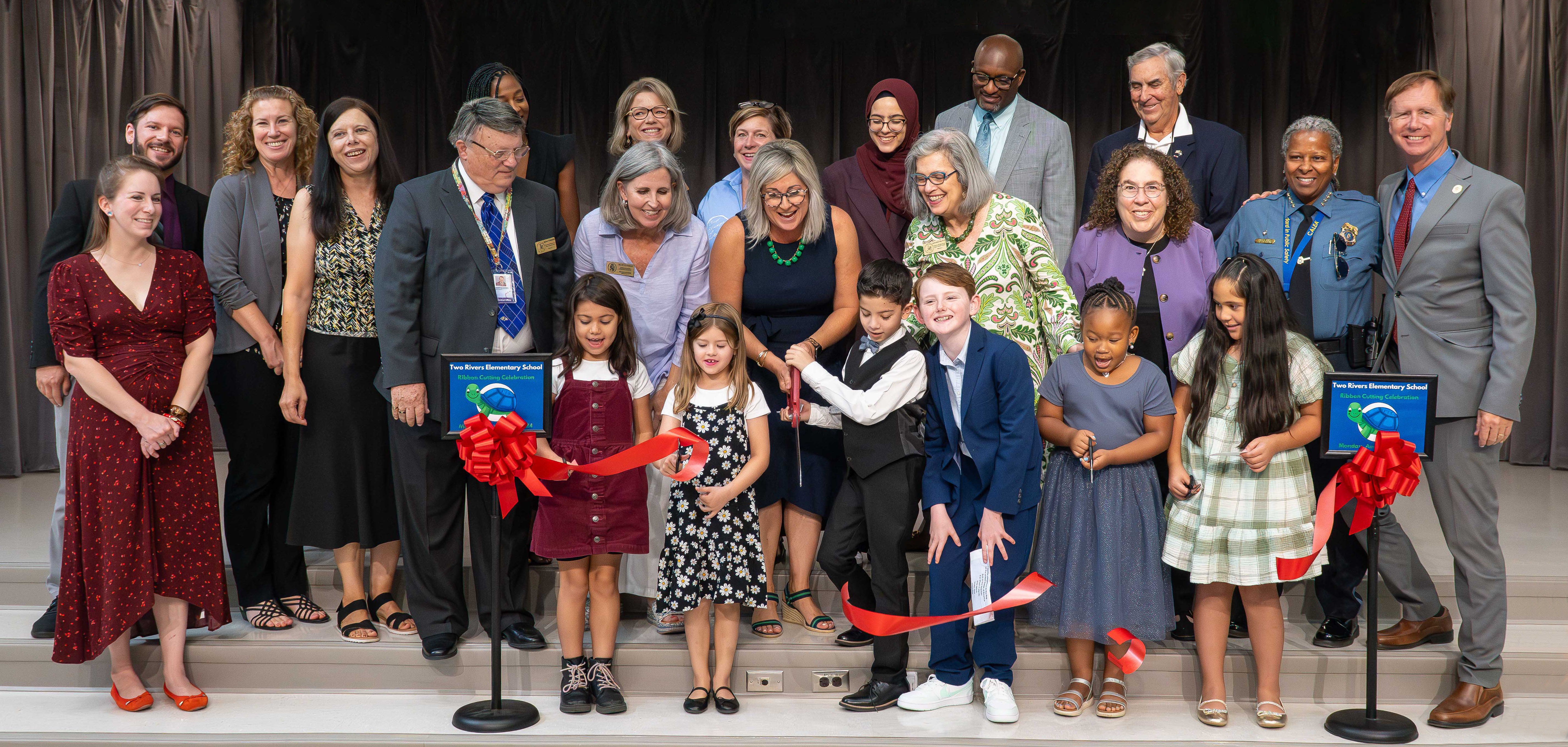 Students and adults participating in ribbon cutting ceremony