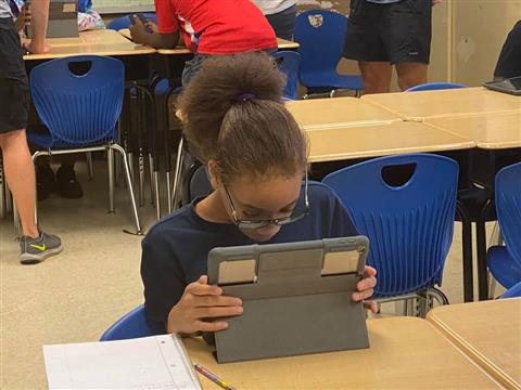 student in the classroom with her ipad