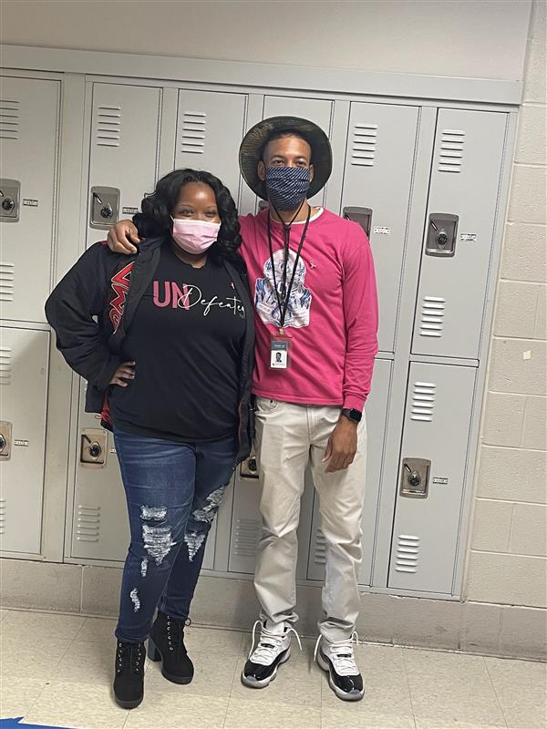 2 persons  wearing a face mask in a school hallway