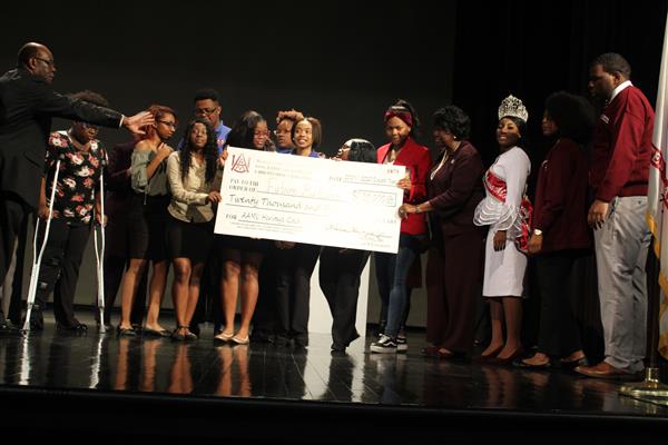 people holding a check on stage 