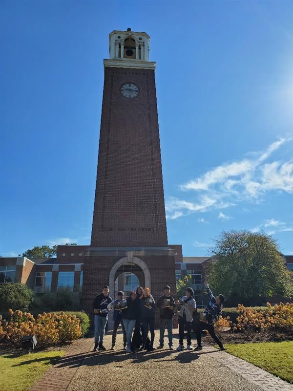 students smiling in front of a tower 
