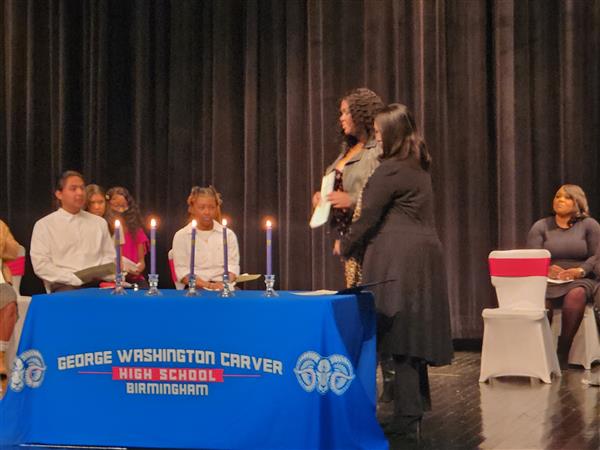 Student receiving an award from a school staff 