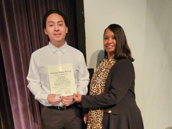 Student receiving an award from a school staff 
