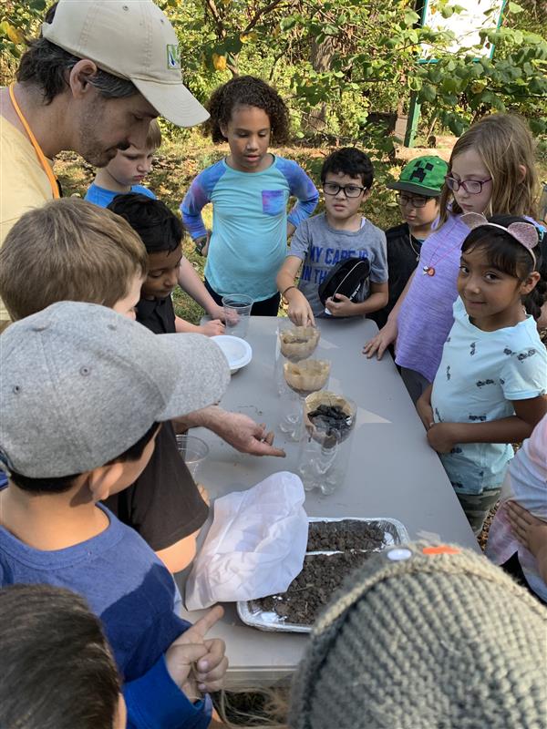 Children gathered around a table, happily eating and socializing with each other.