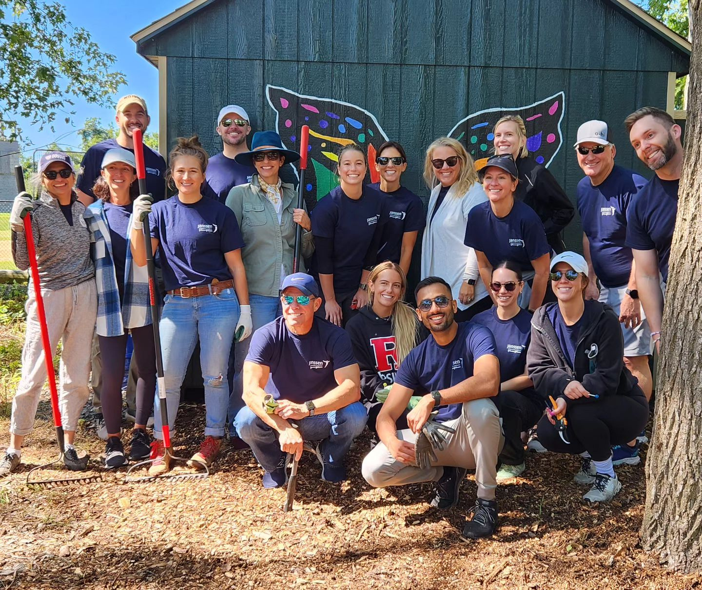 A group of people in blue shirts smiling and posing together for a photo.