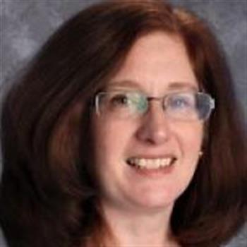 A woman wearing glasses and a blue shirt.