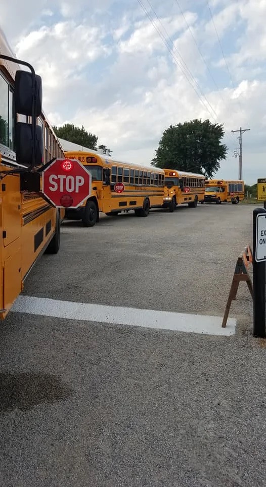 several school buses in line on the street to pick up the students