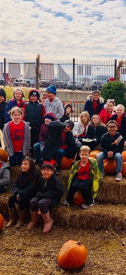 large group of young students outside the school happy