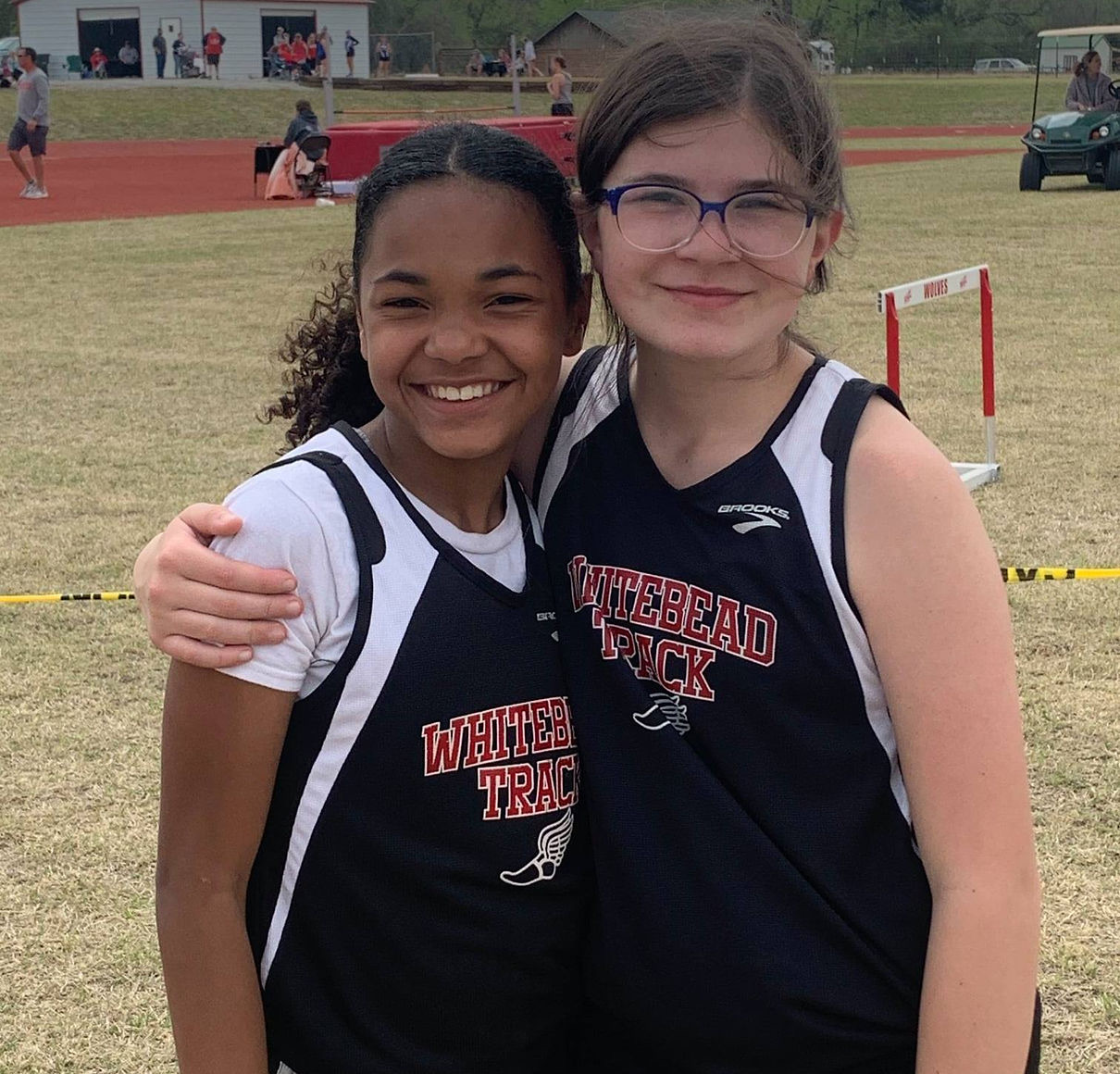 two girl students smiling at the camera with sports uniform