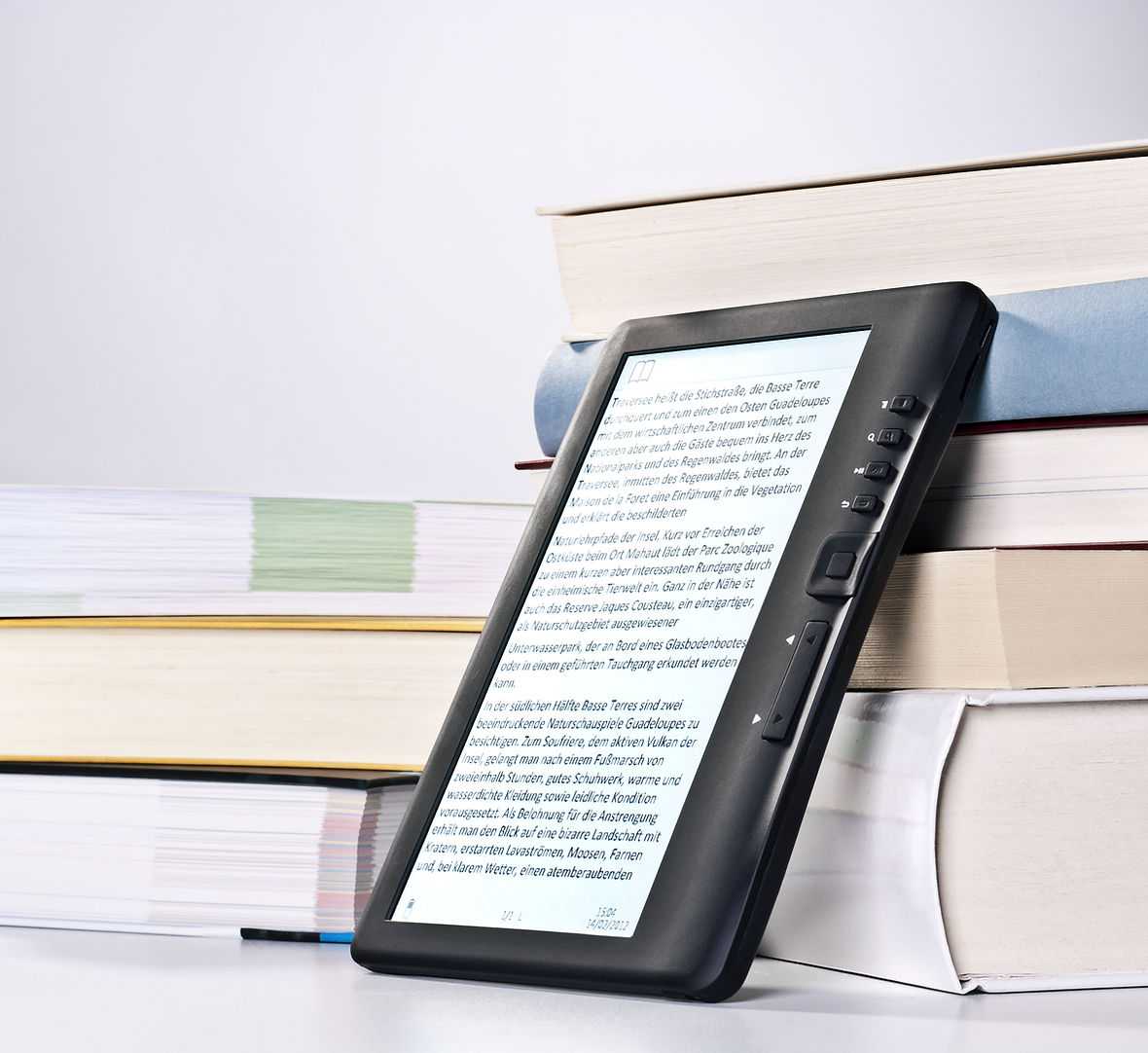 pile of books and in front of it there's a tablet with an e-book