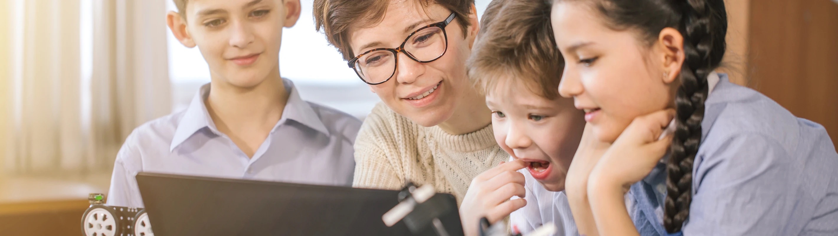 teacher showing something to her students in a tablet, they are happy to learn