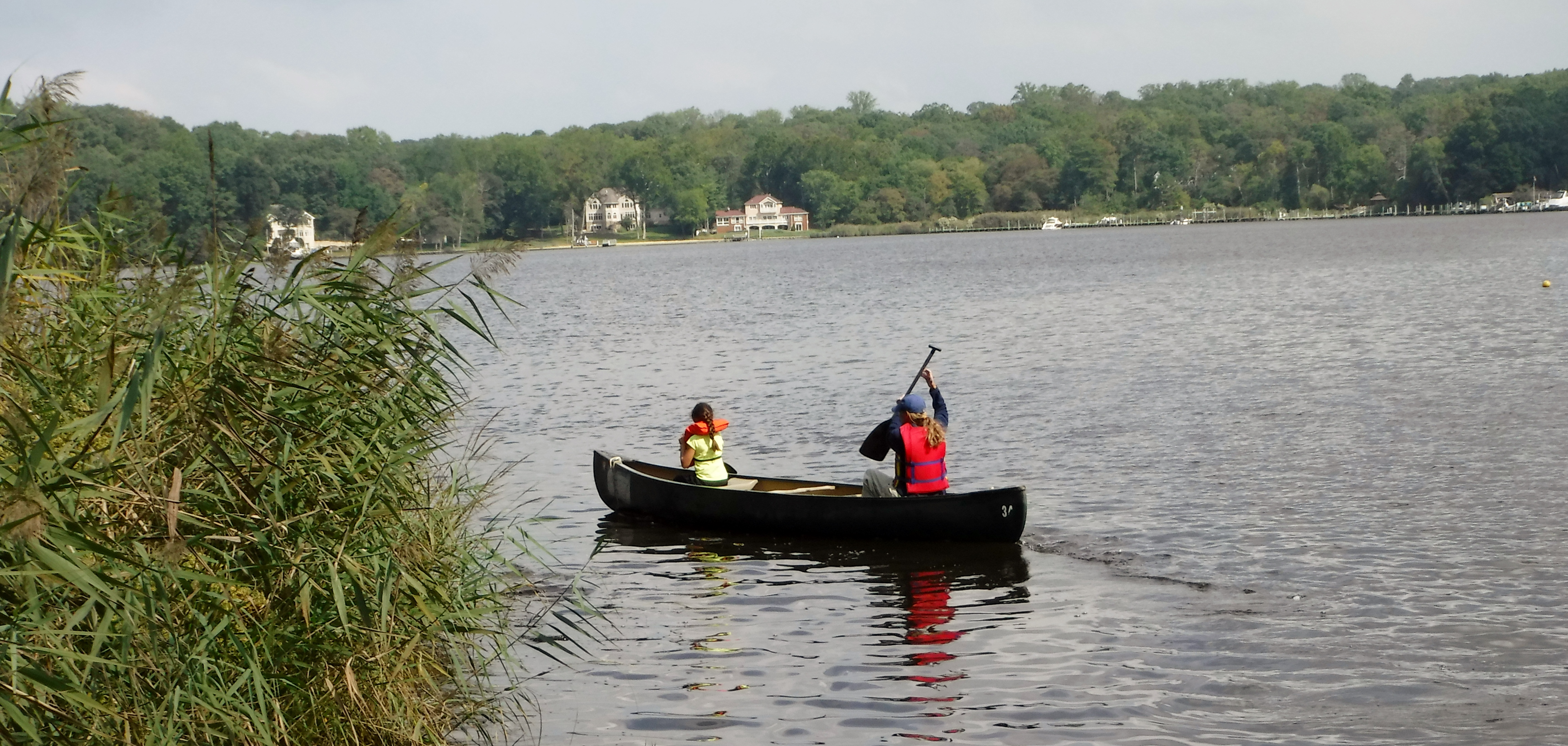 A photo of a two students canoeing on the river. 