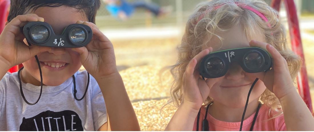 Two kids looking through a pair of binoculars