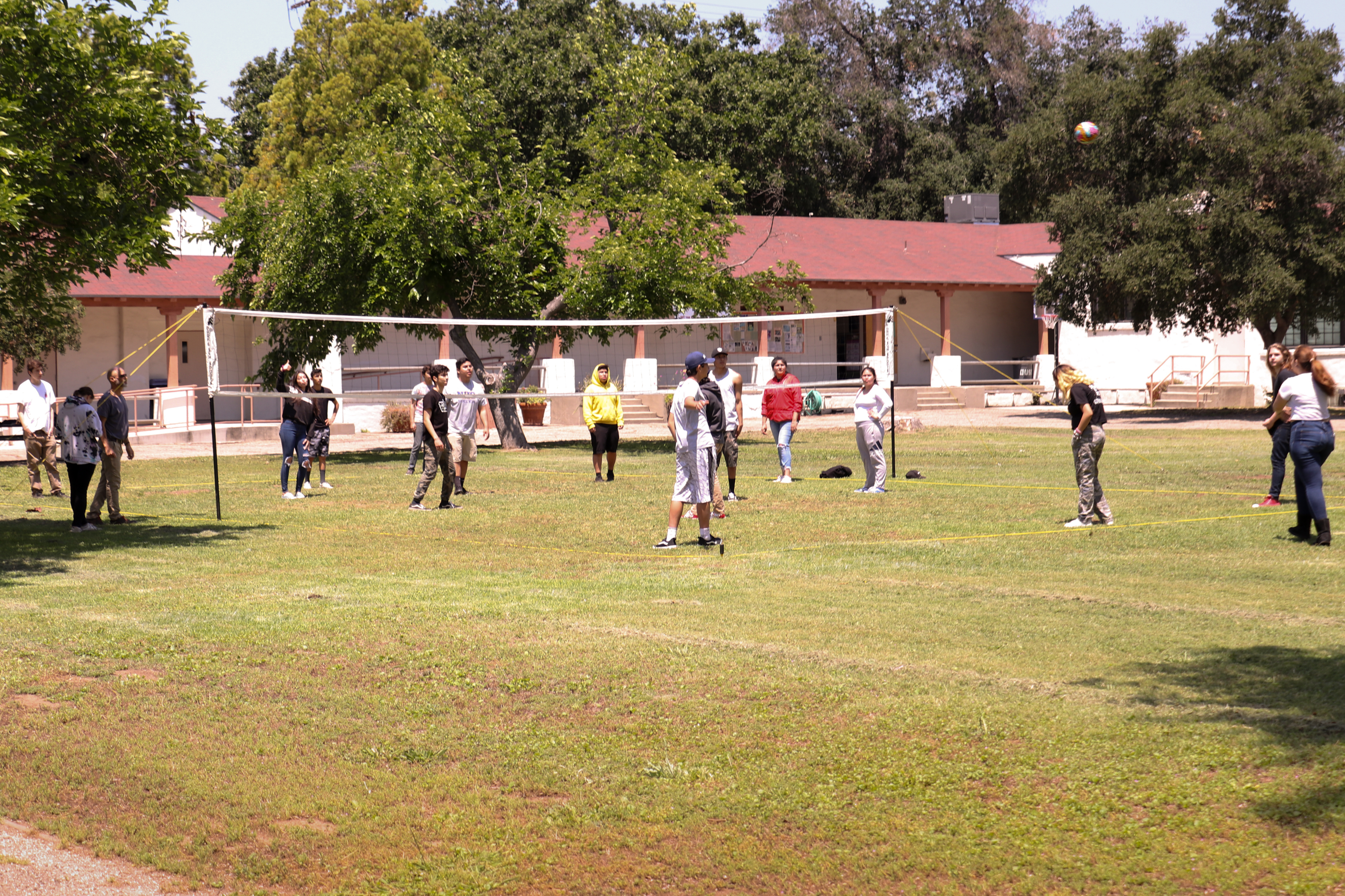 A group of teens all playing soccer in the school's field