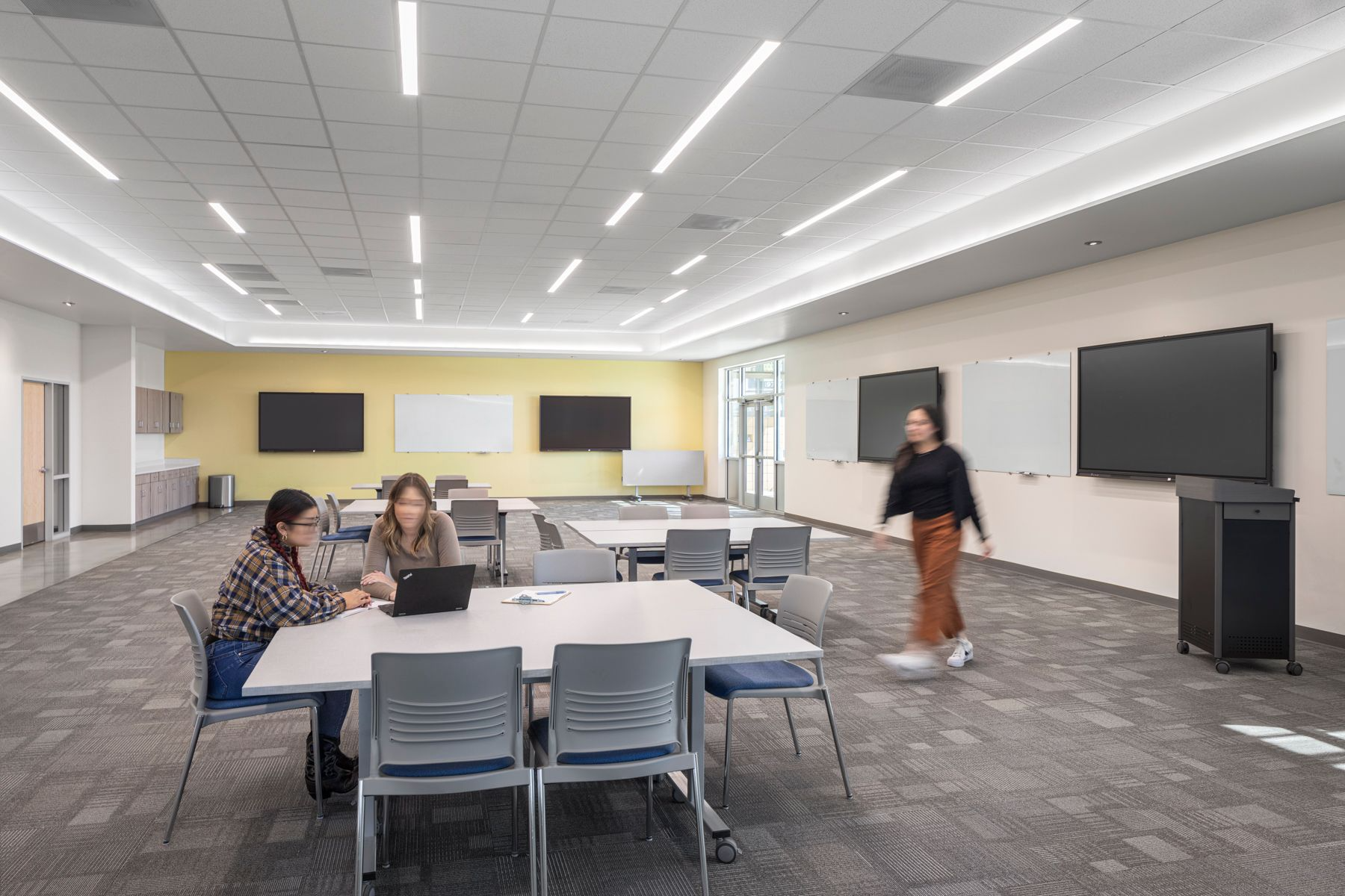 Educators in a mentorship session, collaborating in a modern learning space.