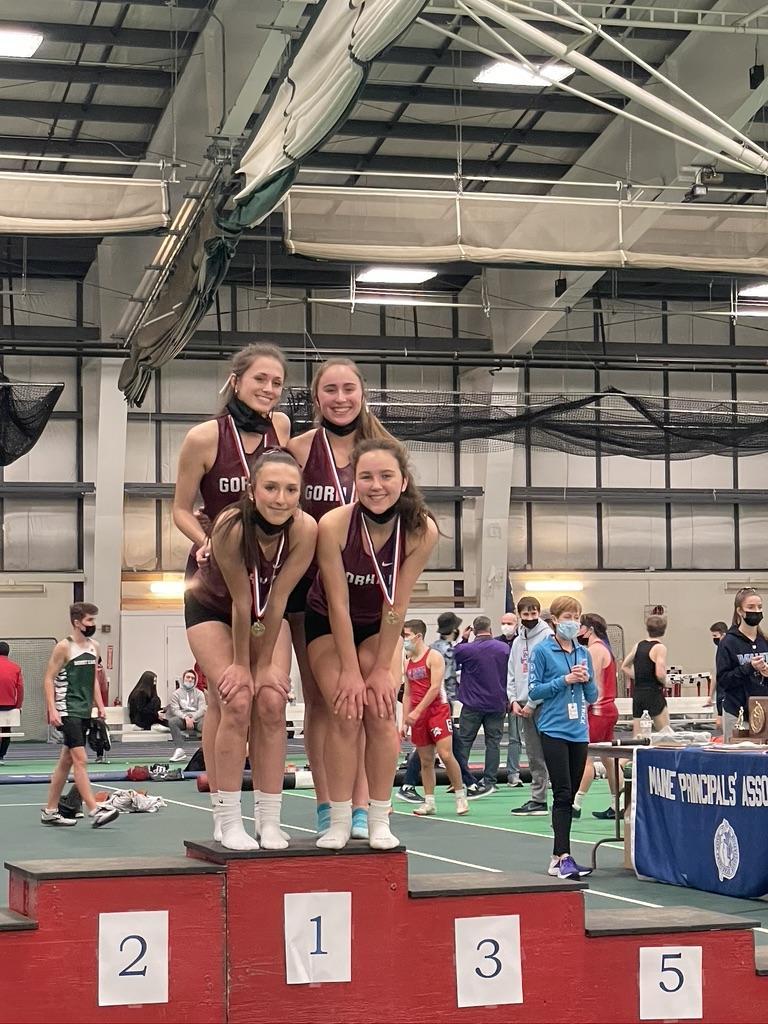 A group of girls wearing masks on a podium.