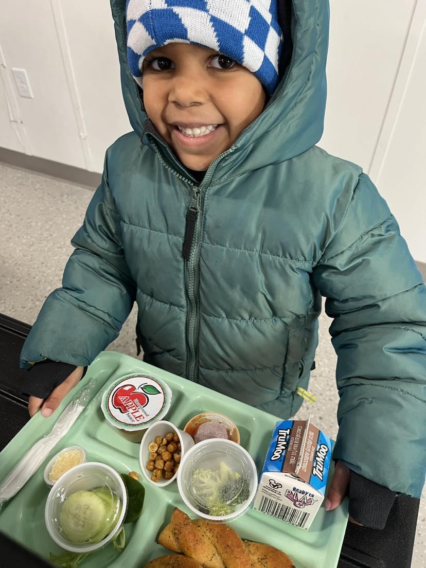 A young boy holding a tray of food