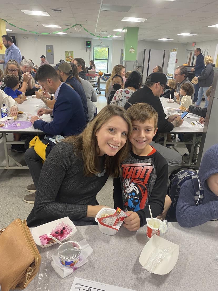 A woman and a boy sitting at a table with food