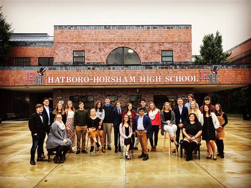 group of people posing for a photo in front of the Hatboro-Horsham High School building