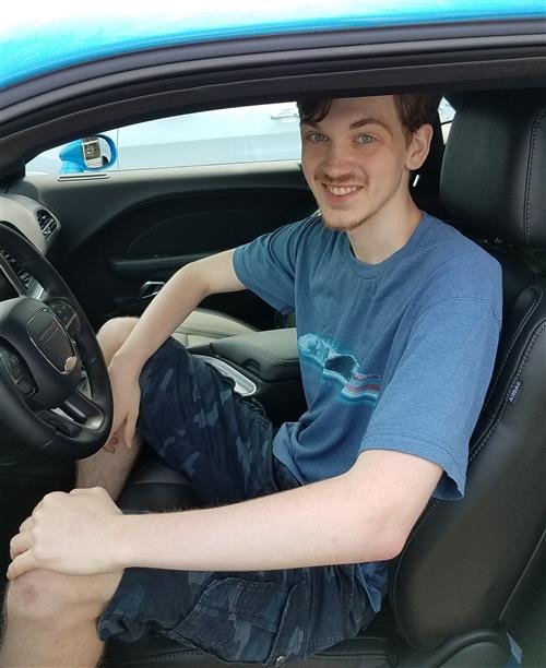 Guy wearing blue shirt in a car