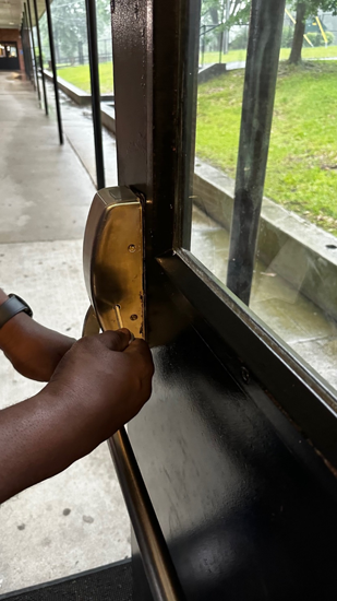 Open black door with a hand unlocking it with a key. 