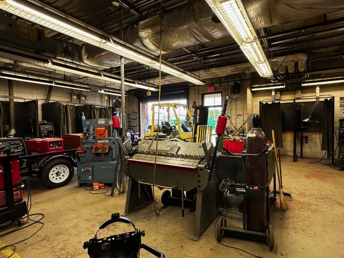 A garage/utility space with an open ceiling and mechanical equipment. 