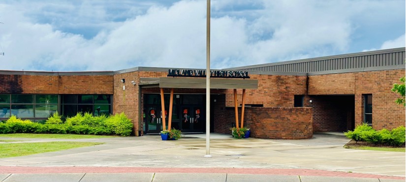 Exterior entrance of a one-level brick school building. 