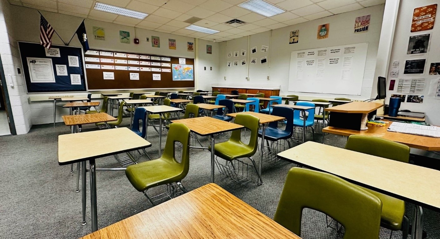 Traditional classroom with individual student desks and seats-half are pea green; half are blue. 