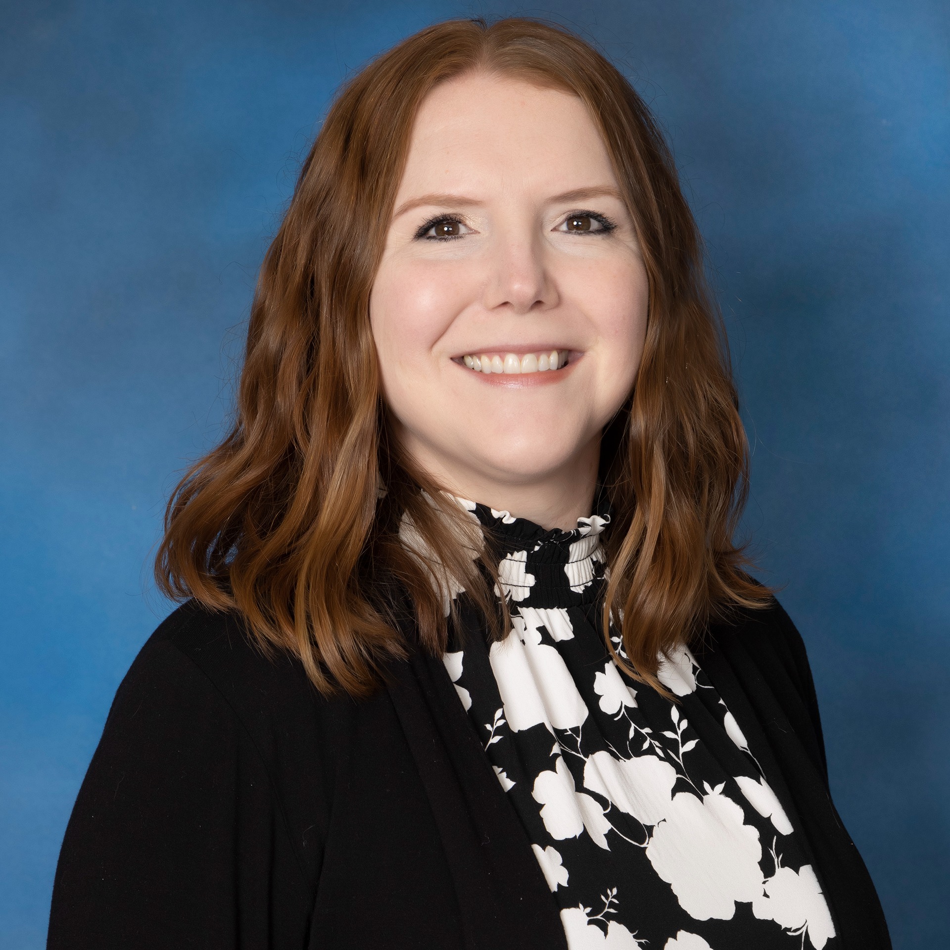 A woman with red hair and a blue shirt.
