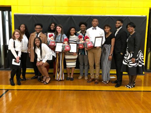 Picture of a group of people holding flowers and diplomas, this is the national honor society group