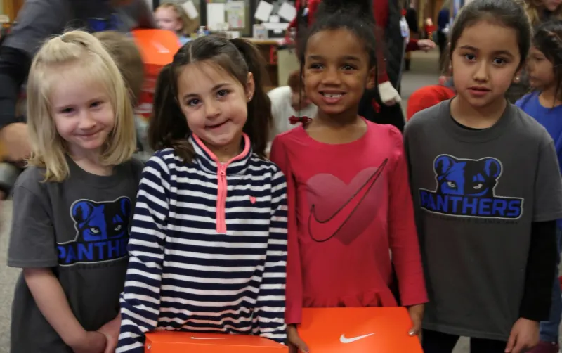 4 girls with nike shoe boxes on their hands