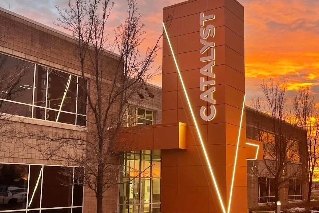 Photo of the front of the catalyst building for davis school district in the evening with the sunset orange in the background