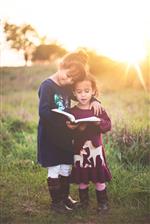 2 girls holding a book