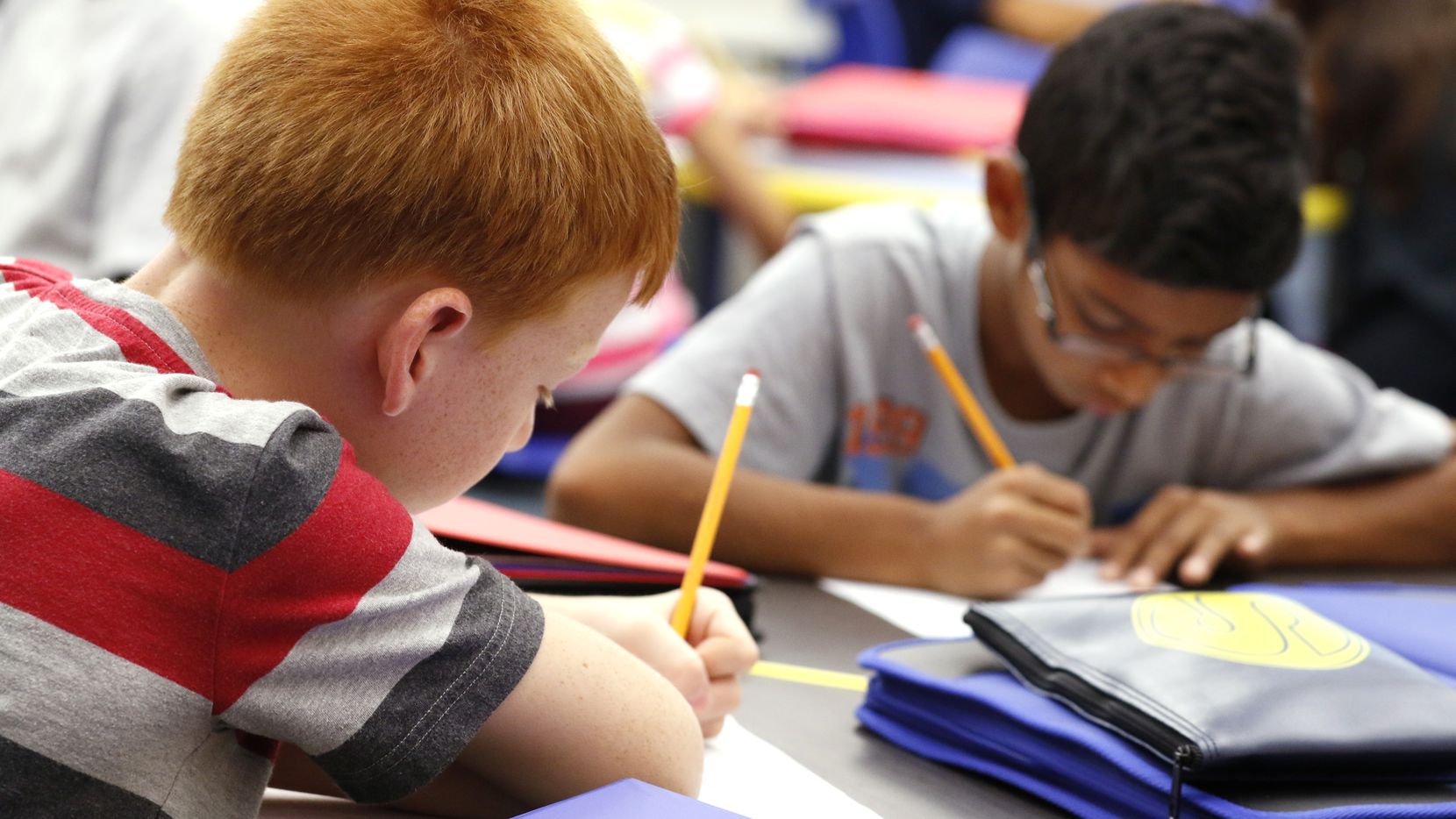 Students writing on notebooks