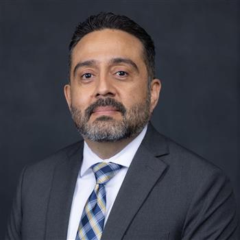 man with beard and mustache in a grey jacket white shirt and tie