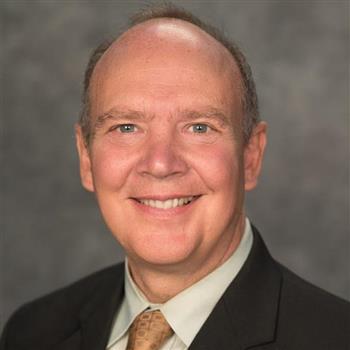 man in a white shirt with gold tie and black jacket