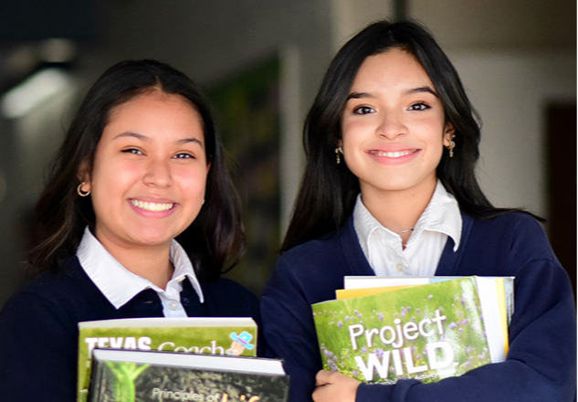 Two smiling students holding books