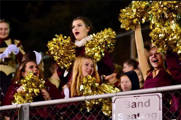 A group of cheerleaders in maroon and gold outfits